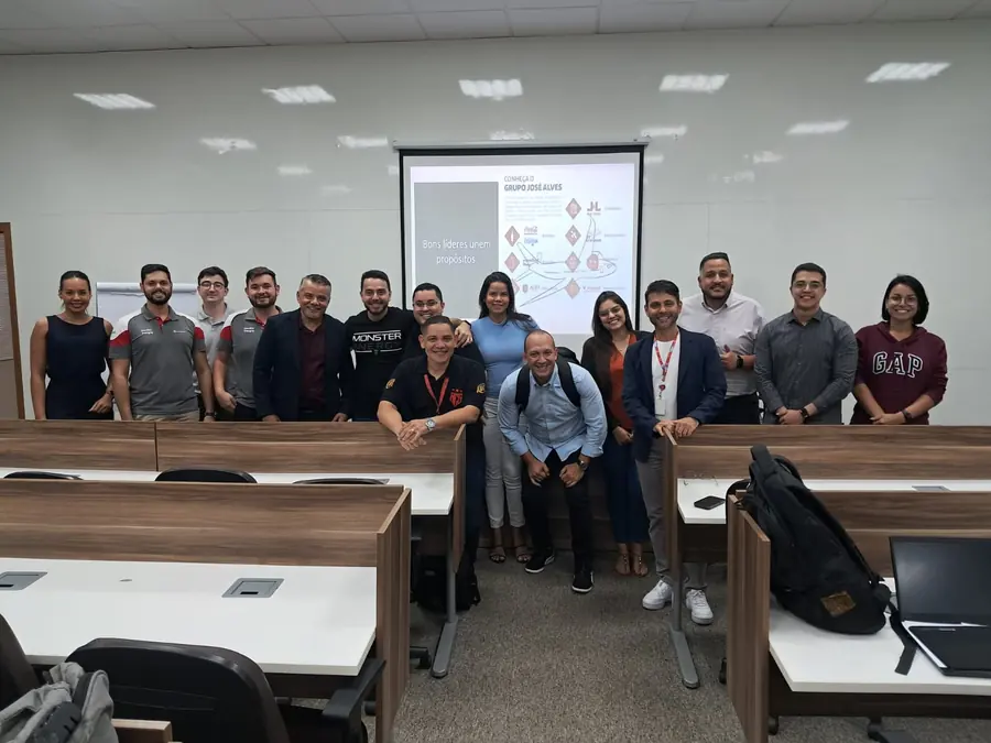 Turma corporativa reunida ao final de um treinamento de liderança conduzido pelo professor