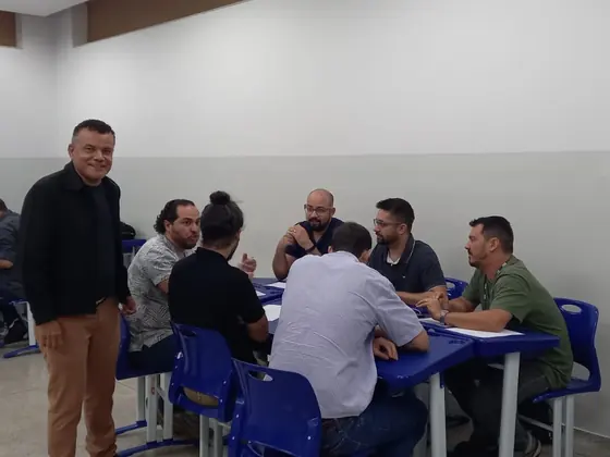 Participantes em dinâmica de grupo ao redor das mesas