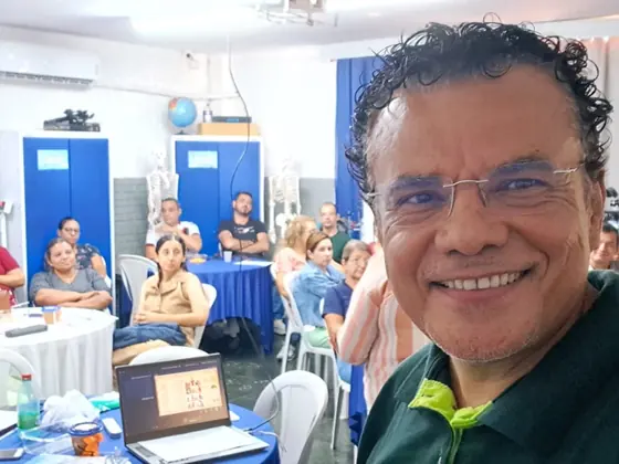 Professor com os participantes de um workshop ao fundo